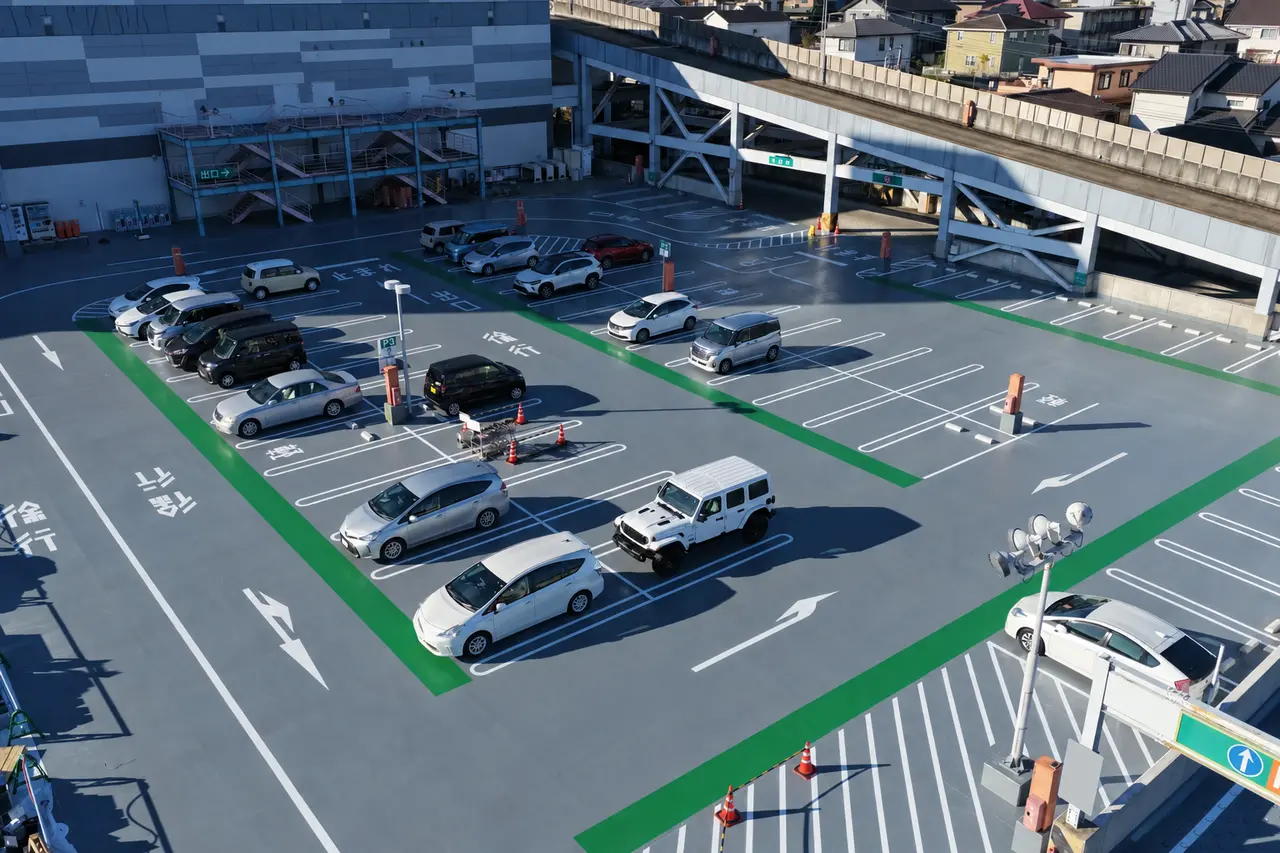 2025年12月9日、白線や緑色の歩行者通路、駐車車両が見える屋上駐車場